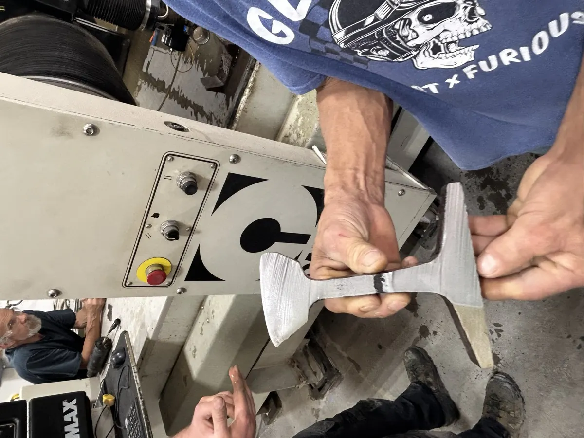 Titan Hydrocut crew inspecting a freshly cut steel part at the OMAX waterjet in the Tucson shop